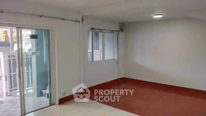 Spacious empty room with sliding glass doors and tiled floor