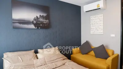 Modern living room with a vibrant yellow sofa, textured blue accent wall, and a sleek air conditioning unit, perfect for comfortable urban living.