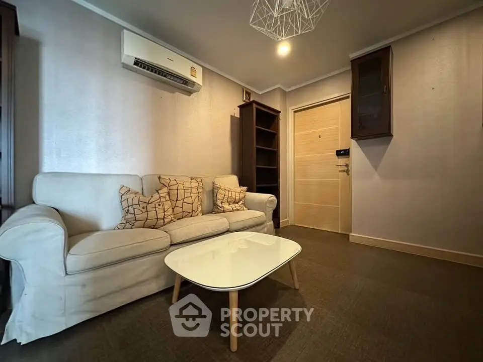 Cozy living room with modern sofa and stylish coffee table in a well-lit apartment.