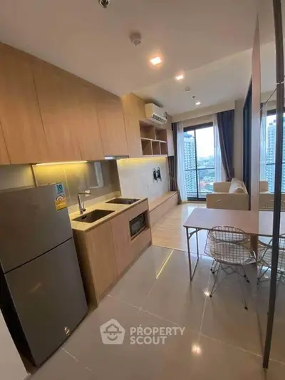 Modern open-layout kitchen and living area with city view in high-rise apartment