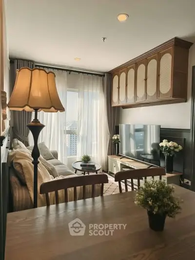 Charming living room with elegant decor and city view, featuring cozy seating and stylish lighting.