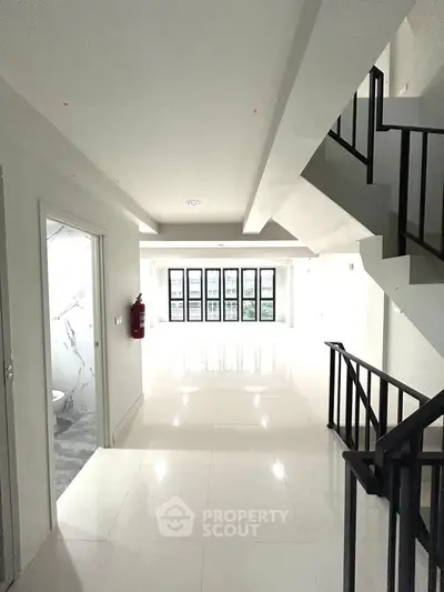 Spacious modern interior with sleek staircase and large windows, perfect for contemporary living.