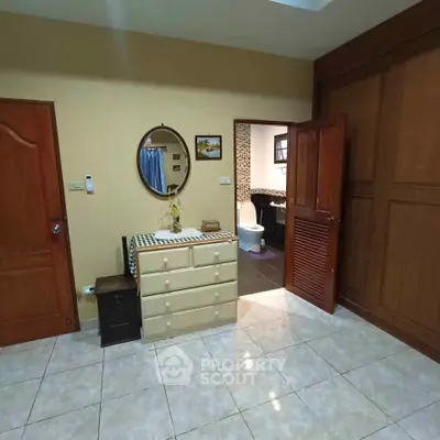 Spacious bedroom with ensuite bathroom and elegant wooden furniture