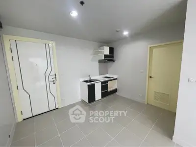 Modern minimalist kitchen with sleek cabinetry and tiled flooring