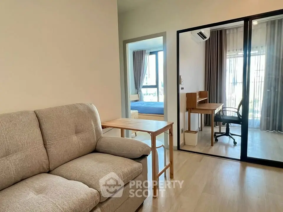 Modern living room with cozy sofa and study area in bright apartment
