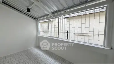 Spacious enclosed balcony with modern metal roofing and tiled flooring.