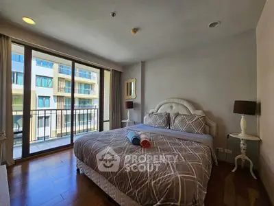 Spacious bedroom with large windows and balcony access in modern apartment