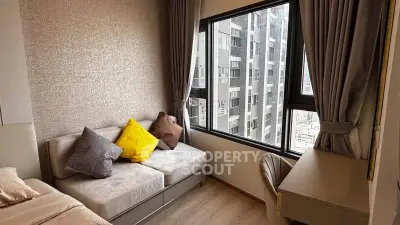 Modern bedroom with cozy sofa and city view, featuring elegant curtains and stylish decor.