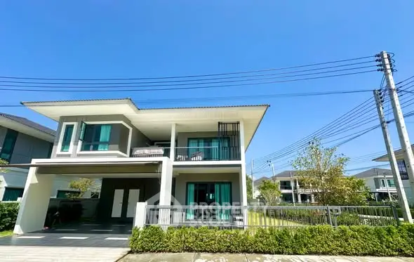 Modern two-story house with large windows and spacious balcony in a serene neighborhood.
