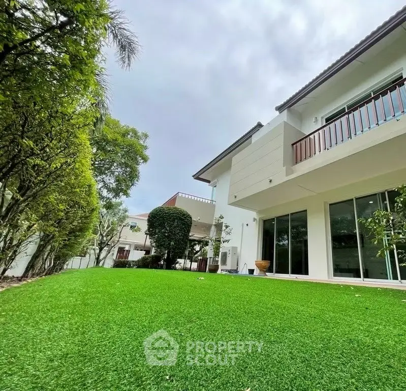 Luxurious modern home with lush green lawn and elegant architecture, perfect for family living.