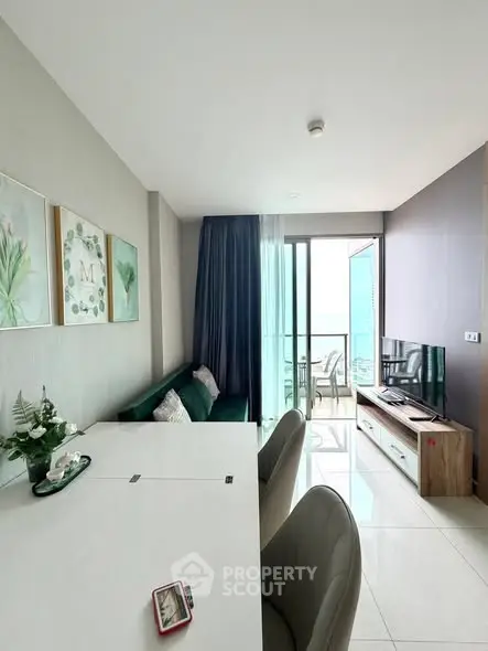 Modern living room with balcony and sea view, featuring elegant decor and natural light.