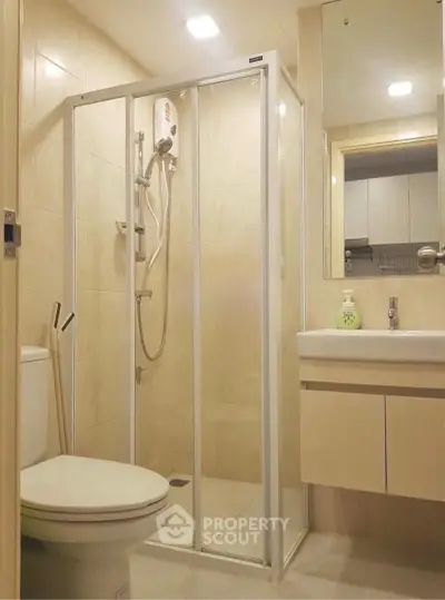 Modern bathroom with glass shower enclosure and sleek fixtures