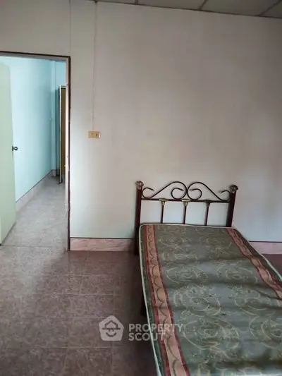 Cozy bedroom with simple decor and tiled flooring, perfect for minimalist living.