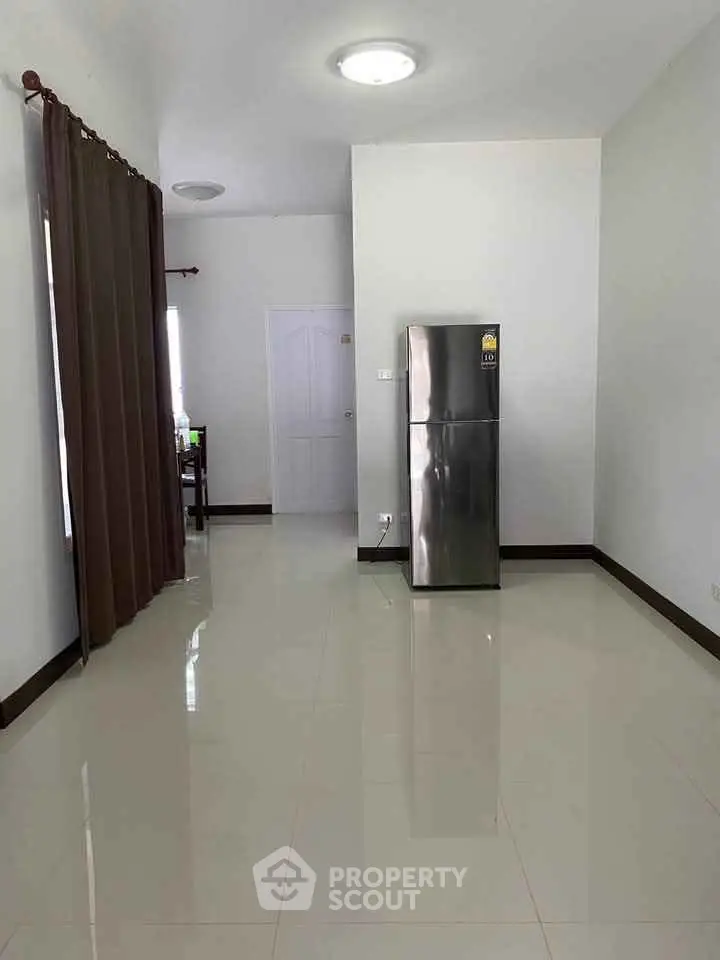 Spacious interior with modern refrigerator and sleek tile flooring
