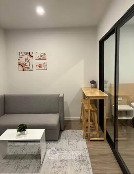 Modern living room with sleek furniture and stylish decor, featuring a cozy sofa and elegant wooden bar table.