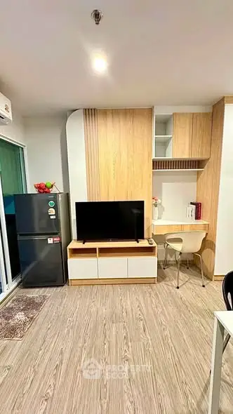 Modern living room with sleek design, featuring a TV, fridge, and stylish wooden cabinetry.