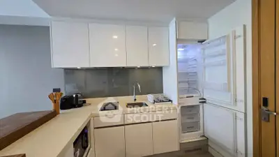 Modern kitchen with sleek white cabinets and open fridge in stylish apartment