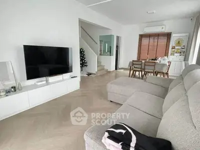 Spacious modern living room with stylish furniture and large TV, perfect for family gatherings.