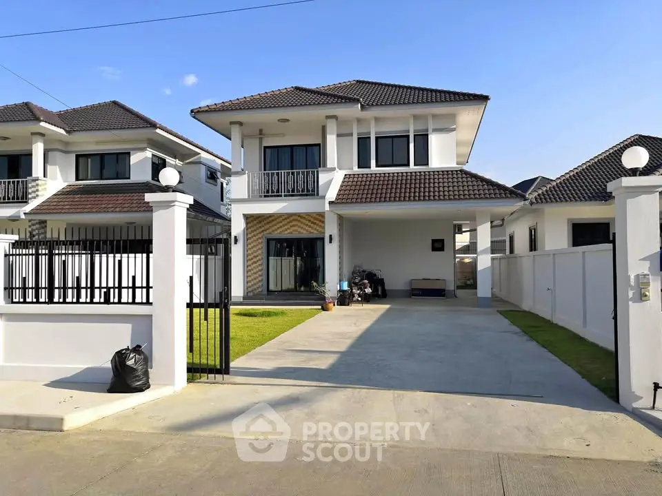 Modern two-story house with driveway and gated entrance in a suburban neighborhood.