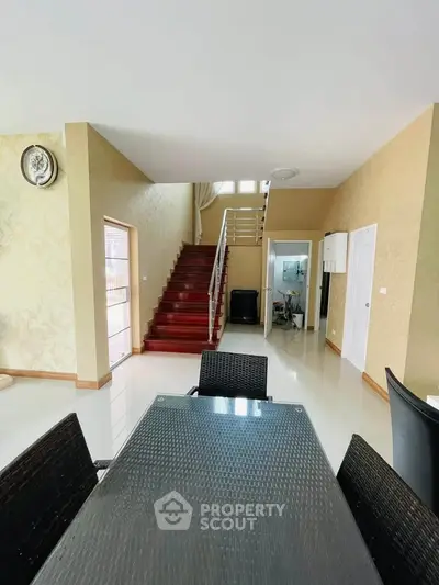 Spacious modern living area with elegant staircase and dining setup