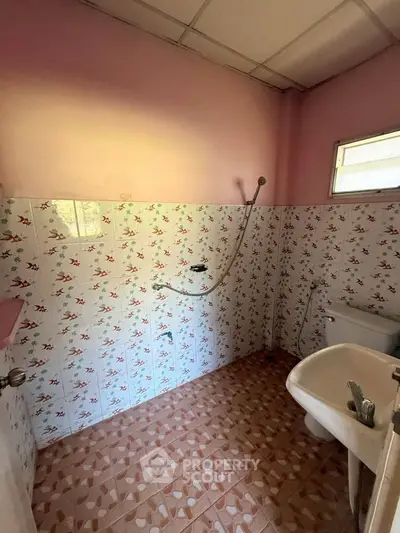 Charming vintage bathroom with floral tiles and natural light, perfect for a cozy home renovation project.