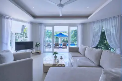 Luxurious living room with pool view, elegant furniture, and abundant natural light.