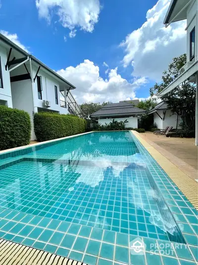 Stunning residential pool area with clear blue skies and lush greenery