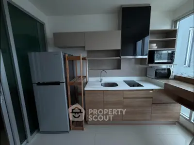 Modern kitchen with sleek cabinets, built-in appliances, and a spacious fridge in a contemporary apartment.
