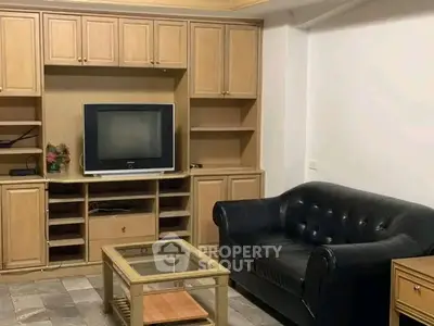 Cozy living room with classic wooden cabinetry and leather sofa