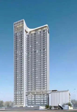 Modern high-rise building with sleek architectural design against clear blue sky.