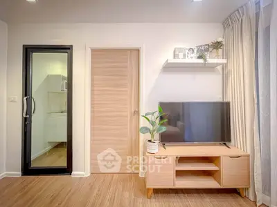 Modern living room with TV stand, glass door, and wooden flooring