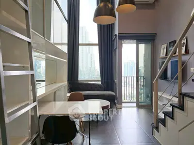 Modern loft apartment with high ceilings and balcony view in urban setting.