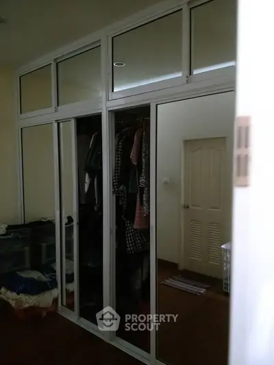 Spacious bedroom with mirrored closet doors and ample storage space.
