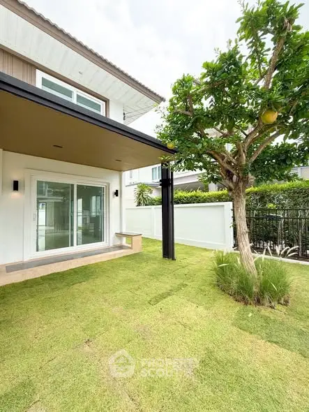 Charming modern house with lush green garden and patio, perfect for outdoor relaxation.