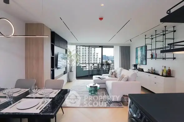 Modern open-plan living room with stylish decor and balcony view in luxury apartment.