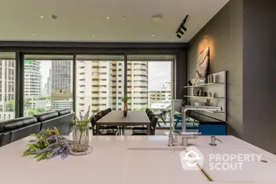 Chic urban apartment with open-plan layout featuring a sleek kitchen, spacious dining area, and a cozy living space with cityscape views through large windows.