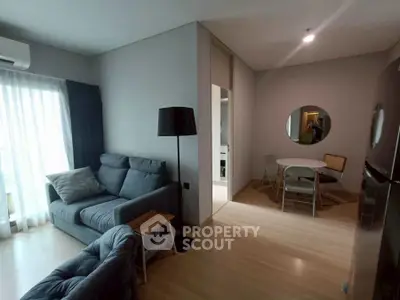 Modern living room with cozy seating and dining area in open layout apartment.