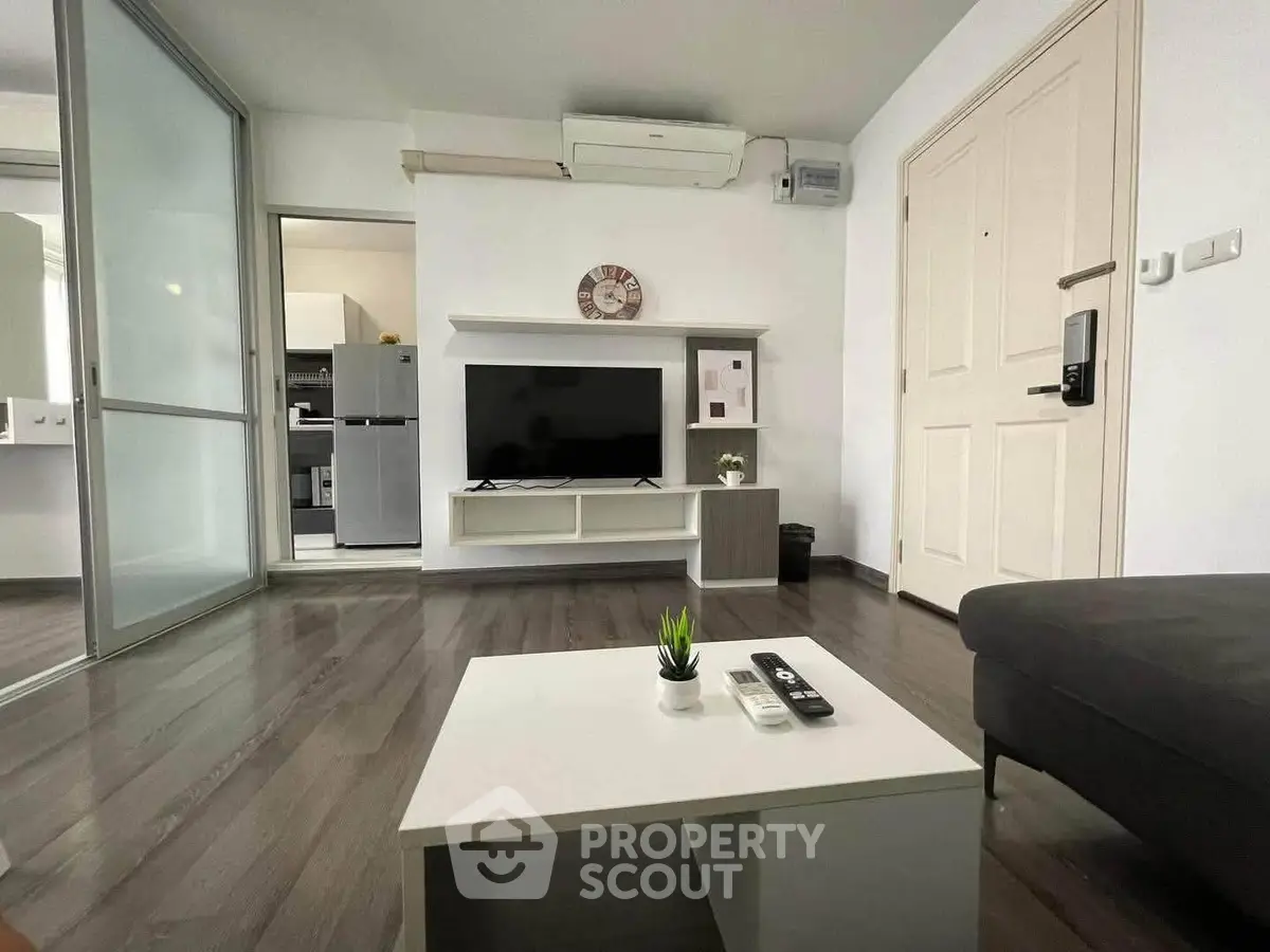 Modern living room with sleek design, featuring a TV, air conditioning, and stylish decor.