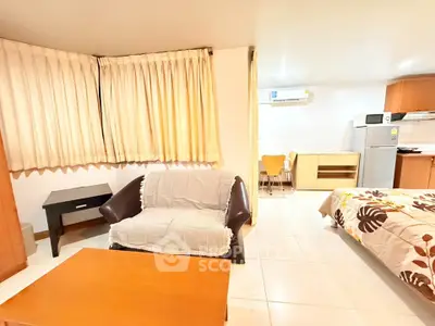 Spacious studio apartment with cozy living area and modern kitchen appliances.
