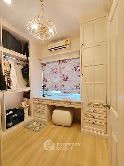 Elegant study room with chandelier, built-in storage, and natural light.