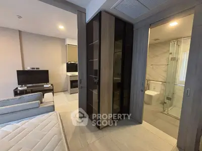 Modern studio apartment with sleek bathroom and cozy living area, perfect for urban living.