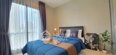 Modern bedroom with large window and stylish decor in a cozy apartment.