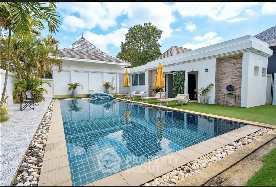 Luxurious villa with private pool and sun loungers in tropical setting