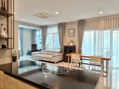 Spacious modern living room with large windows and elegant decor, perfect for family gatherings.