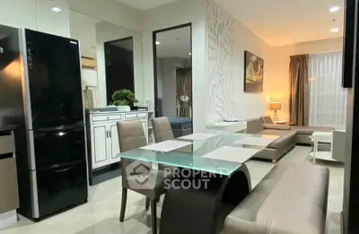 Modern living room with sleek furniture and glass dining table in a stylish apartment.