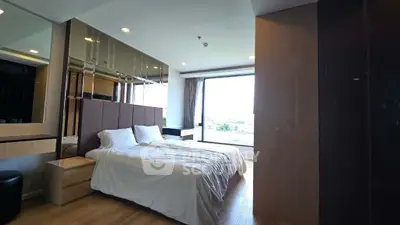 Luxurious bedroom with large window offering stunning views and modern decor.