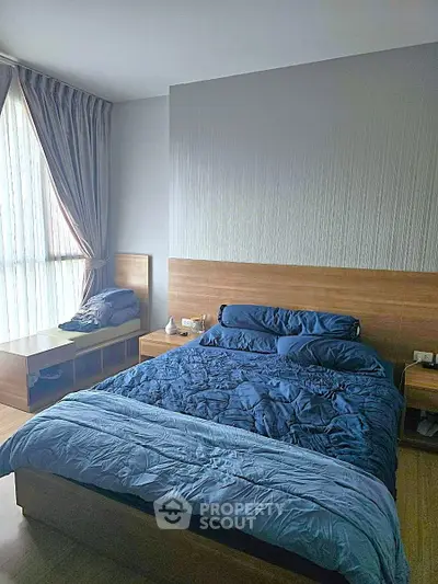 Modern bedroom with stylish wooden furniture and cozy blue bedding, perfect for relaxation.