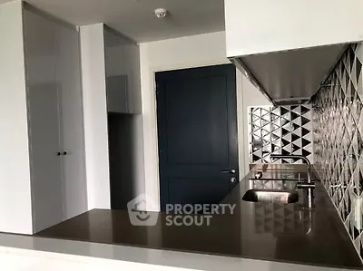 Modern kitchen with sleek countertops and geometric backsplash design