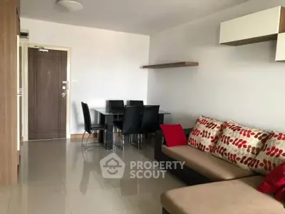 Modern living room with stylish sofa and dining area in open layout apartment.