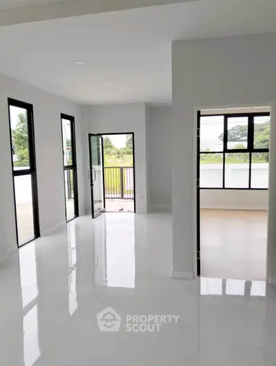 Spacious modern living area with large windows and balcony access